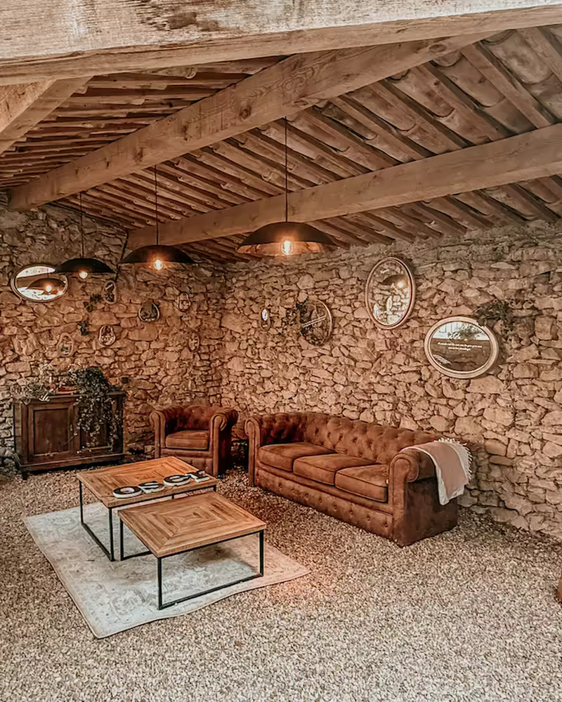 Le salon en pierre, sous la charpente, au Hameau de l'Esperelle